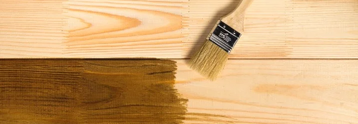 Pinsel trägt Holzlasur auf Bretter auf